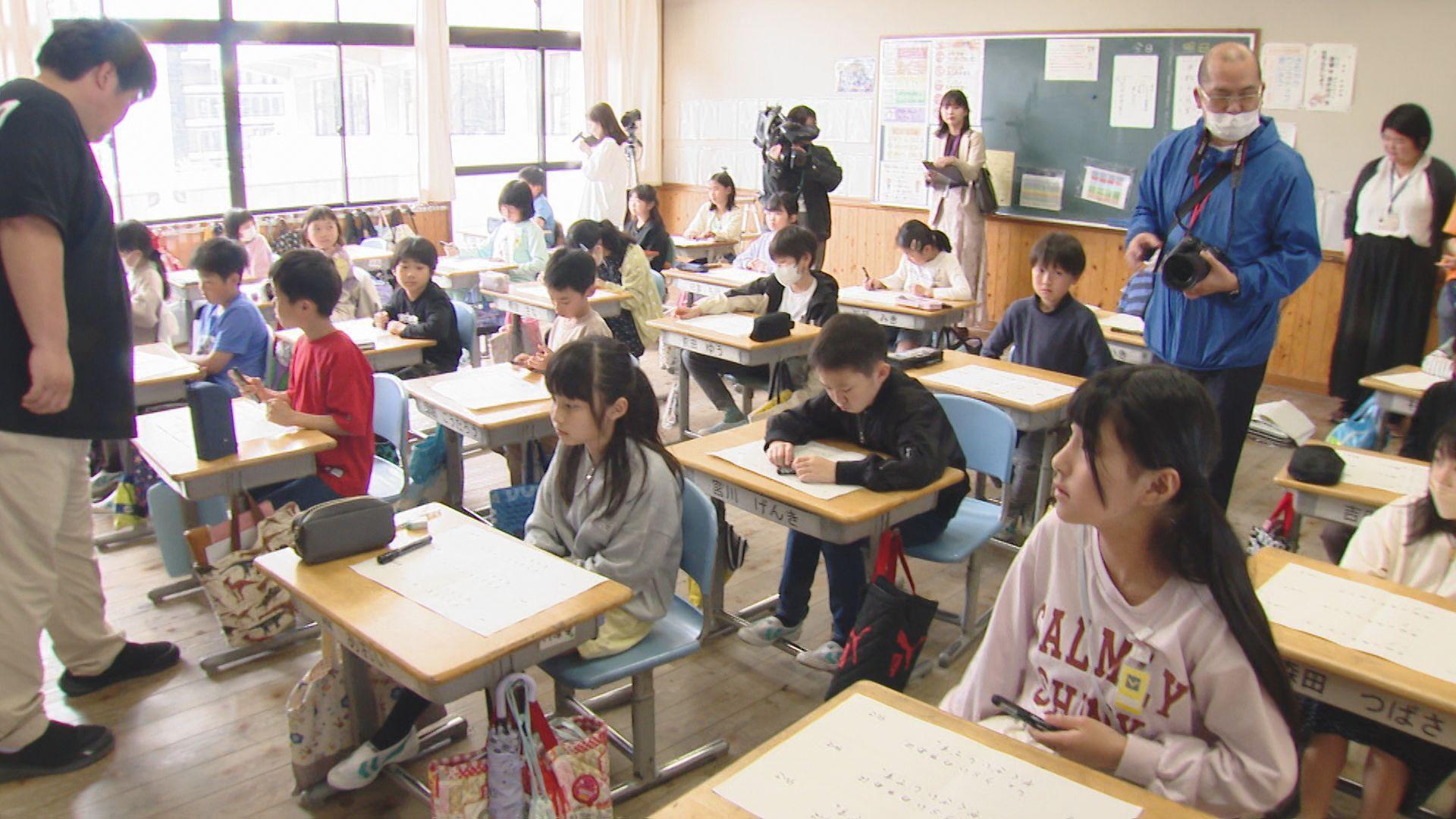 建築中の長崎トヨタ本店のレンガに小学生が「夢を刻む」